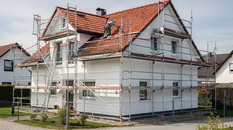 Dachfanggerüst mit Dachdecker bei der Arbeit