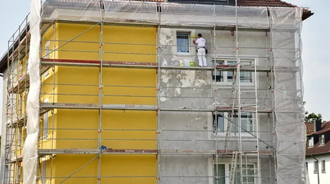 Gerüst mit Malerplane an frisch gestrichenem Wohnhaus